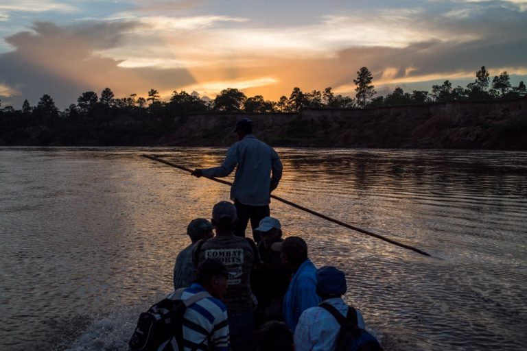 Personas cruzando río en panga